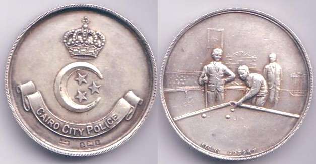 EGYPT SILVER UN-DATED KING FAROUK CAIRO CITY POLICE MEDAL
Round Shaped 39 MM SILVER Diameter Medal, weights almost 24 Grams. 
Obverse DEPICTS Royal Crown, Crescent with 3 Stars (Egypt Flag) & Cairo City Police. 
Reverse shows two players son a billiard table & medal recipient Number # 693 287. 

Keywords: Egypt King Farouk Silver Cairo City Police Bronze Medal Order Royal Royalty Ibrahim Pasha Signed Mohamed Ali